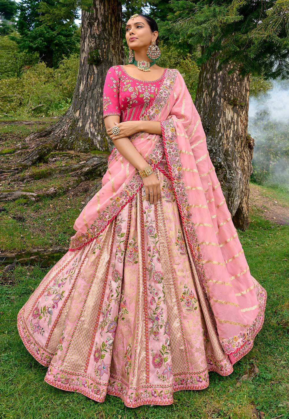 Photo of Bride twirling around in a baby pink lehenga.